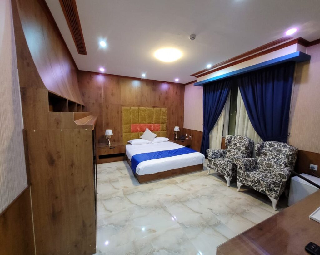 Single room with a double bed and armchairs